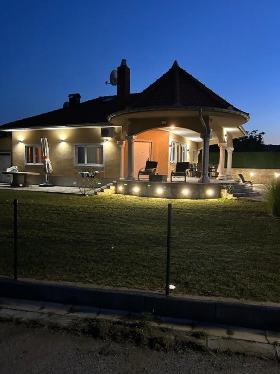 a house with lights on the lawn at night at Vila Danica in Golubac