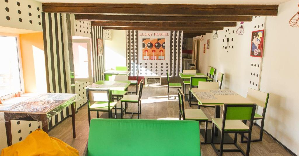 a dining room with green and white tables and chairs at Lucky Hostel на Крещатике in Kyiv