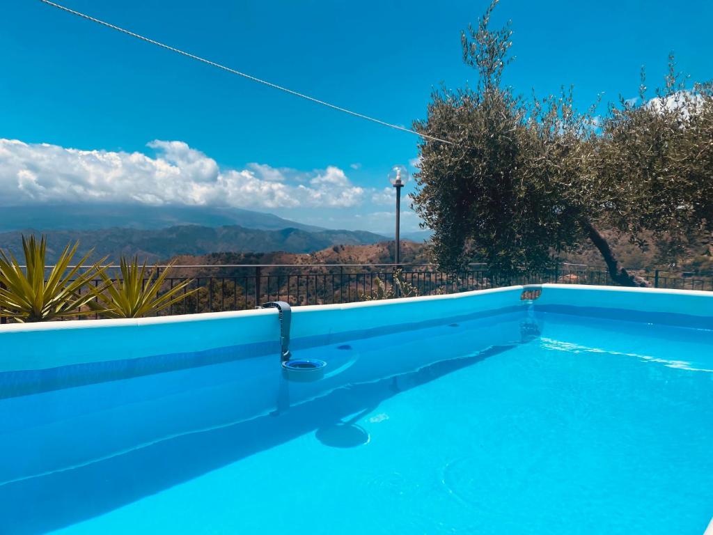 a swimming pool with a view of the mountains at Tenuta Guardavaglia in Castelmola