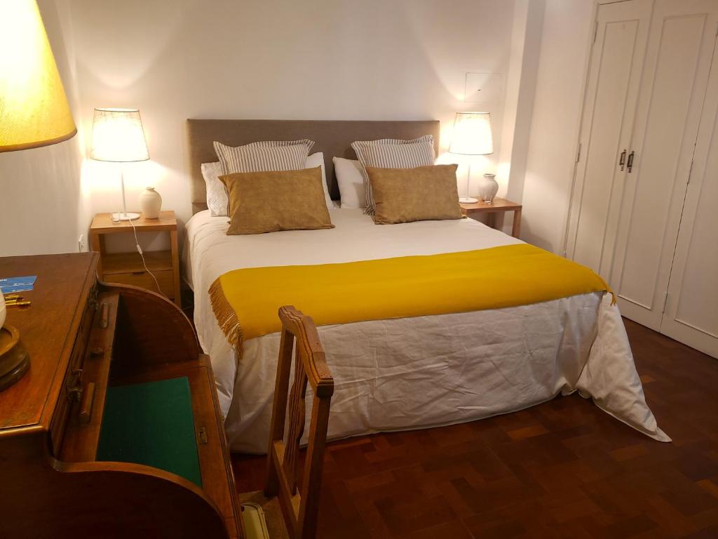 a bedroom with a large bed with yellow sheets at A Friendly Room in the Heart of Recoleta -in Shared Apartment- in Buenos Aires