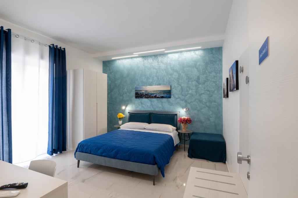 1 dormitorio con cama y pared azul en B&B BISCEGLIE, en Bisceglie