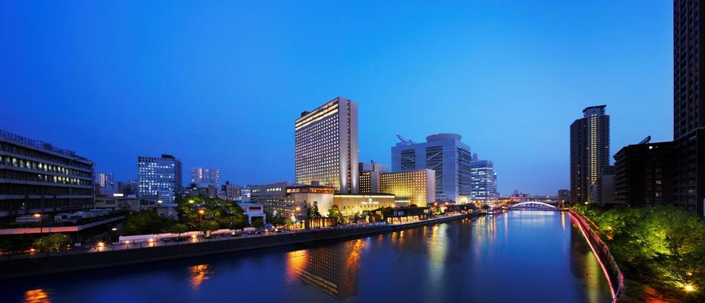 a river in a city at night with tall buildings at RIHGA Royal Hotel Osaka in Osaka