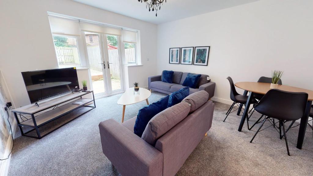 a living room with a couch and a tv and a table at Blakelock House Hartlepool Horizon Stays in Hartlepool