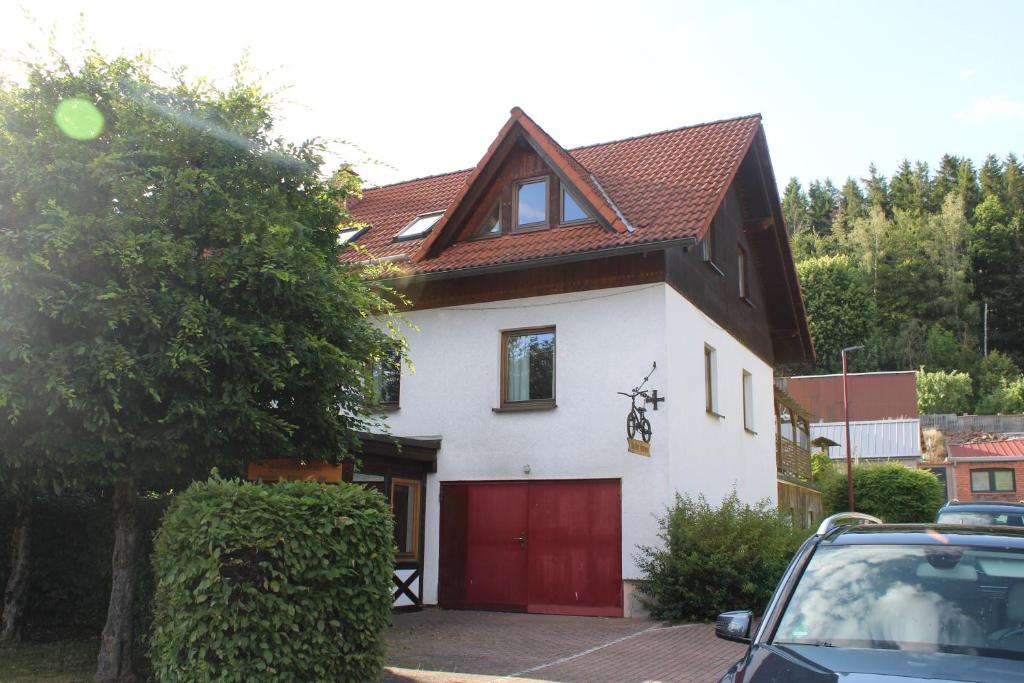 a white and red house with a red garage at Die Radler-Scheune Finsterbergen in Friedrichroda