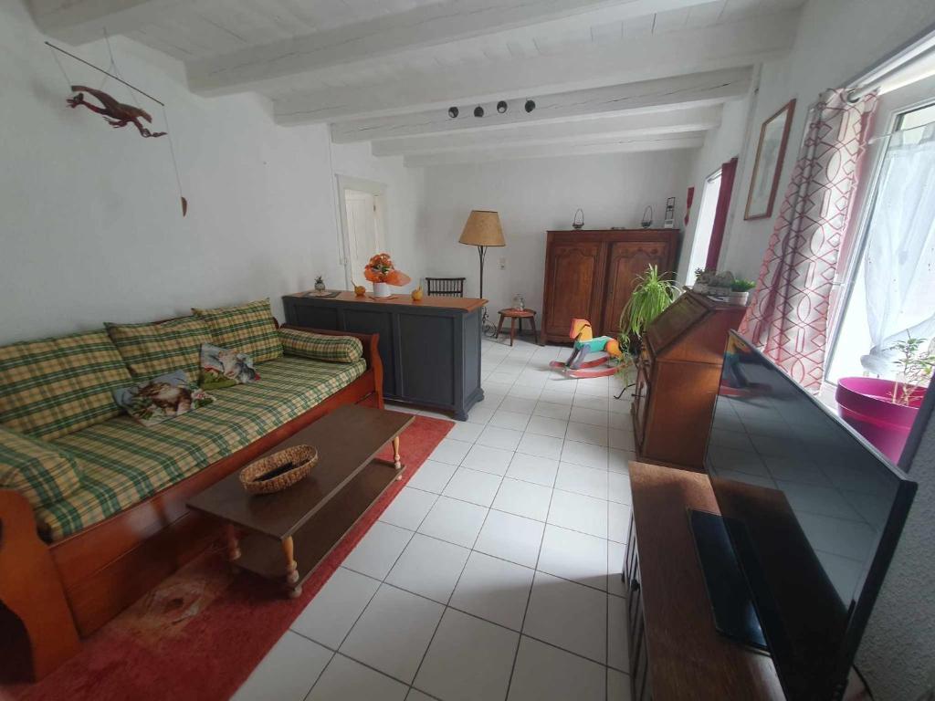 a living room with a couch and a table at Gite des 3 Cailloux in Leulinghen-Bernes