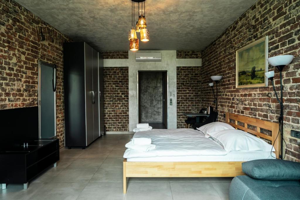 um quarto com uma cama grande numa parede de tijolos em Hotel JURKOS em Příbram