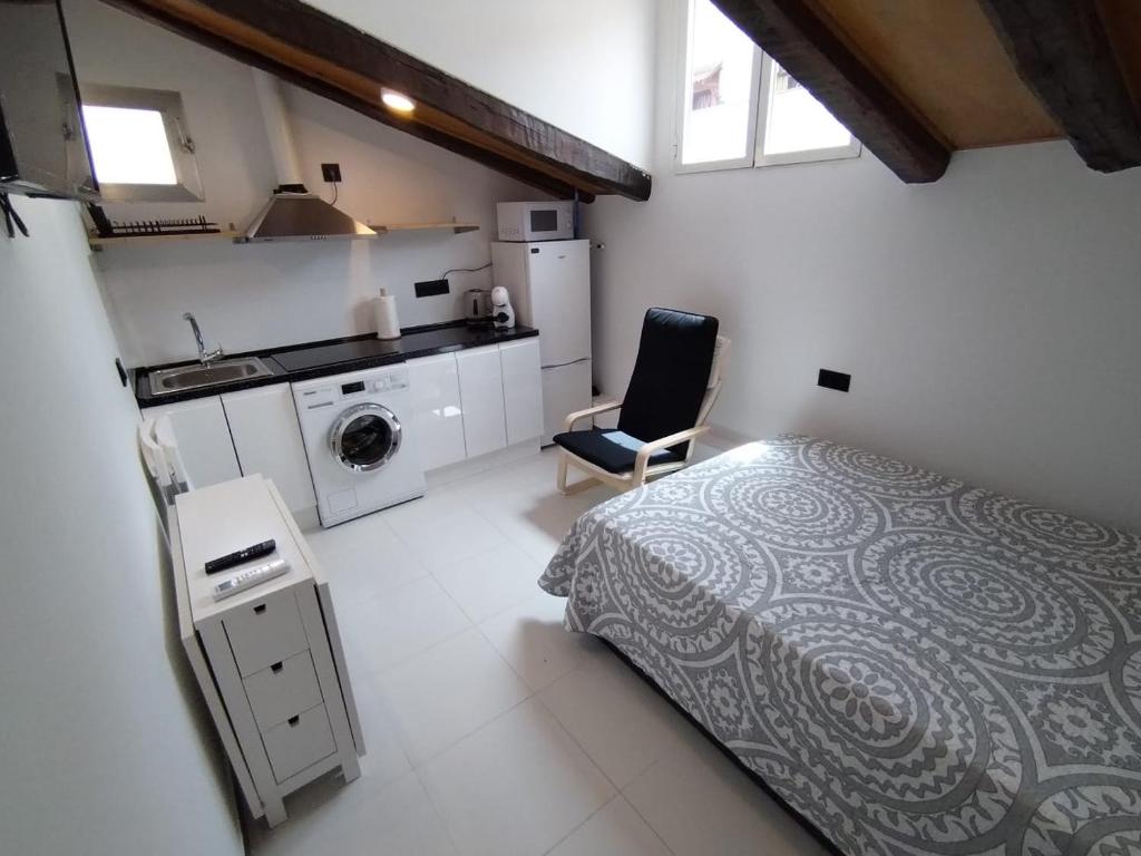 a small bedroom with a bed and a kitchen at Estudio Centro - Puerta del Sol in Madrid
