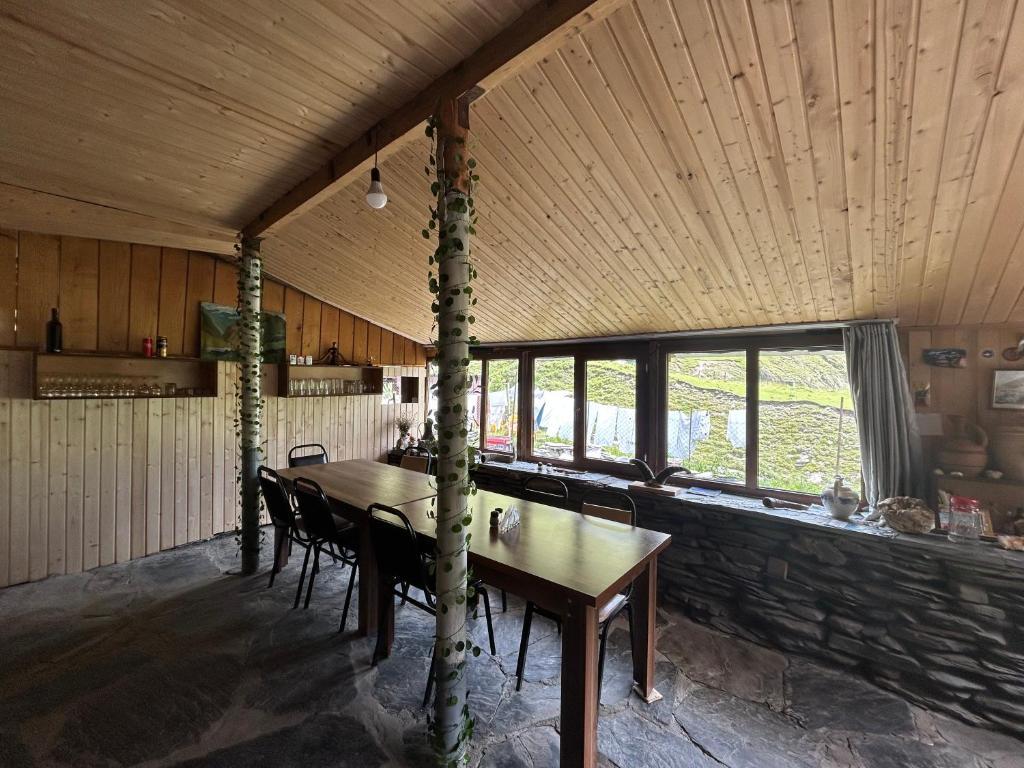 una sala da pranzo con tavolo e sedie in legno di Shio's Stonehouse in Tusheti a Tusheti