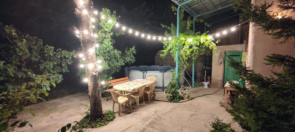 un patio con una mesa, un árbol y luces en Villa singola, en Arrinj