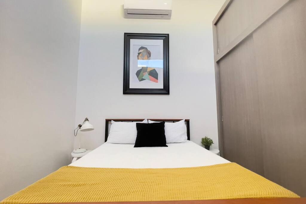 a bedroom with a bed with a yellow blanket on it at Condominiums Boutique Madera 3 in Ciudad Juárez