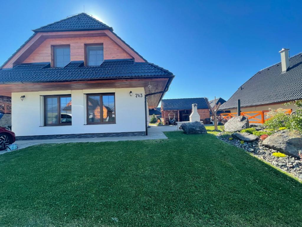 a house with a yard with green grass at Vila Snezienka in Stará Lesná