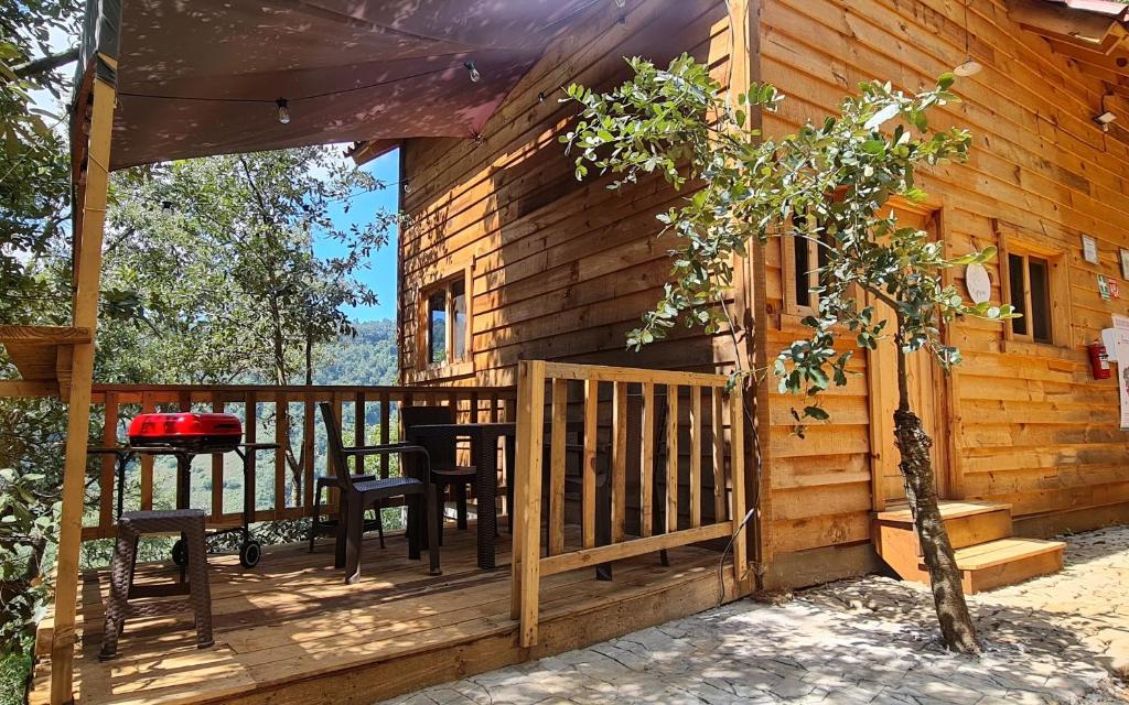 a porch of a cabin with chairs and a table at Mariposa - Cabañas Puerto del Zopilote in Pinal de Amoles