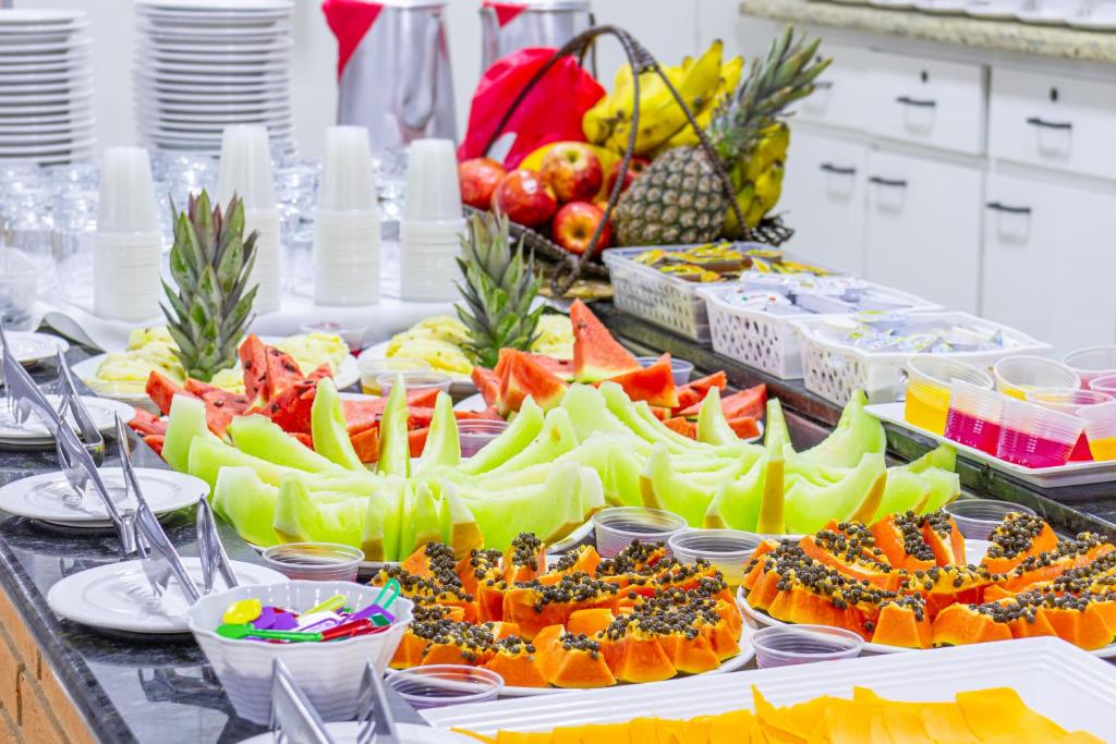 a buffet of fruits and vegetables on a table at Hotel Caminho do Rosário in Aparecida