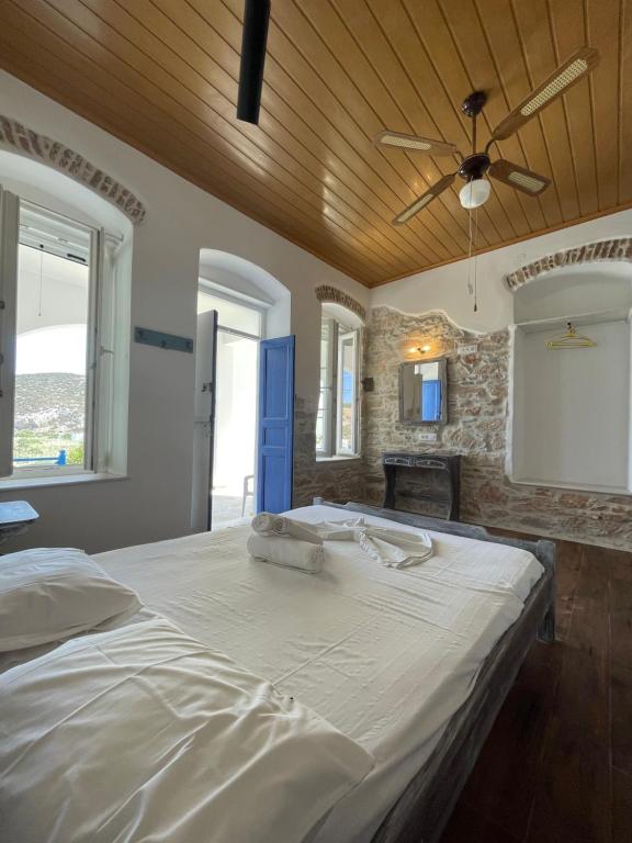a bedroom with a large bed with a ceiling fan at KROISSOS in Galissas