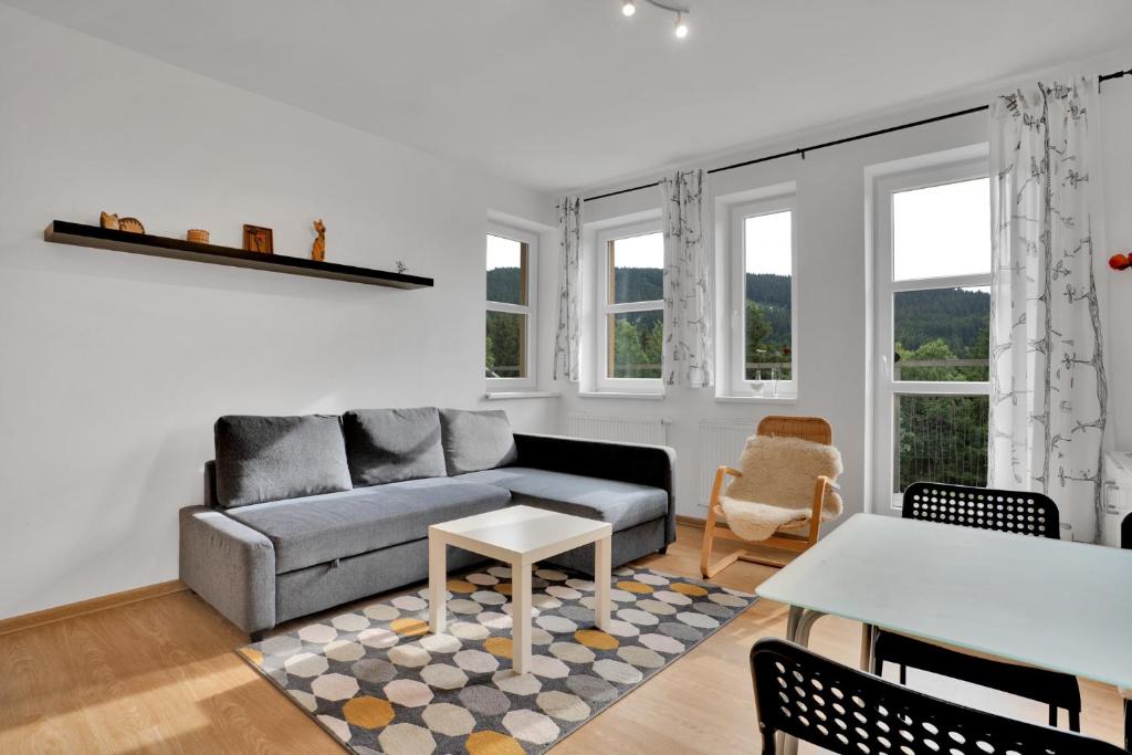 uma sala de estar com um sofá e uma mesa em Horský Apartmán Klínovec 4 em Loucná pod Klínovcem