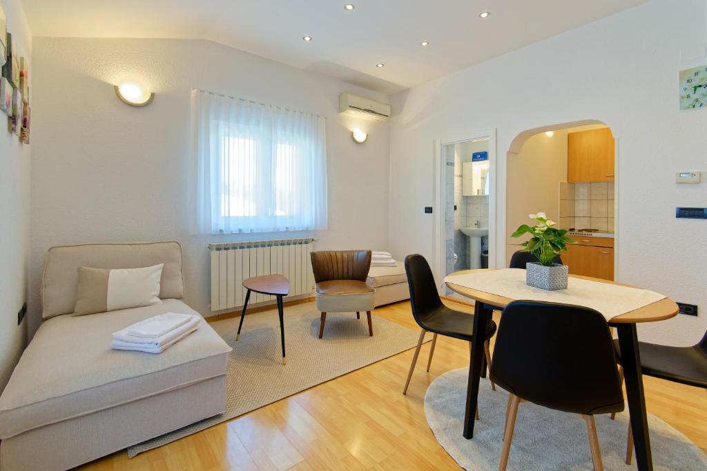 a living room with a couch and a table at Apartments Sunliving in Vilanija