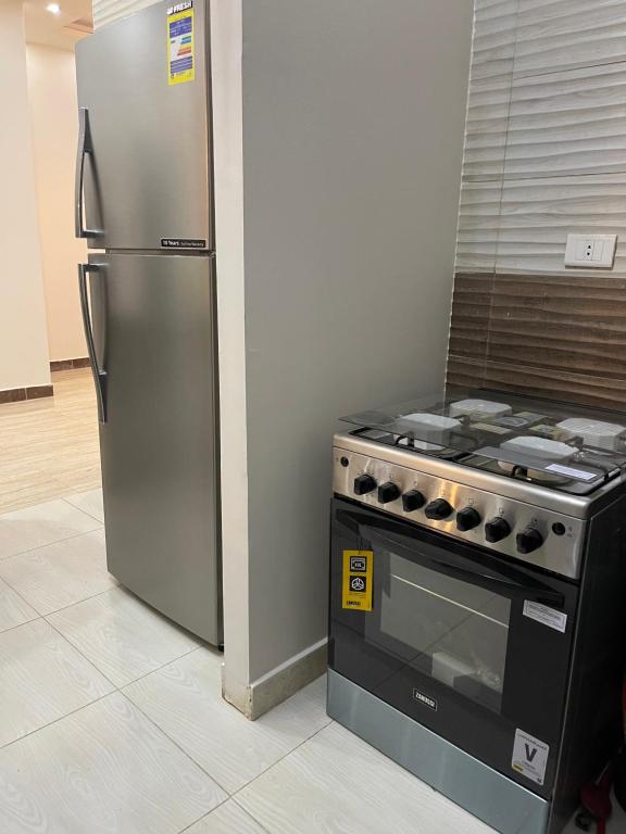 a stainless steel refrigerator and a stove in a kitchen at Modern Apartment 3 room in Sheikh Zayed N5 الشيخ زايد in 6th Of October
