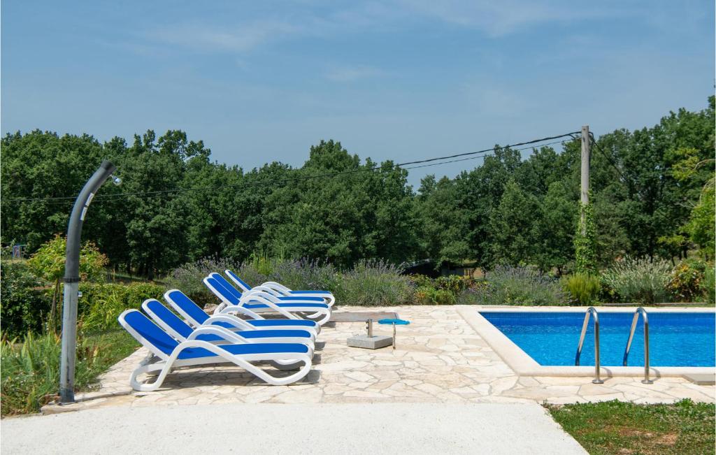 grupa krzeseł siedzących obok basenu w obiekcie 3 Bedroom Amazing Home In Ruzici w mieście Ružići
