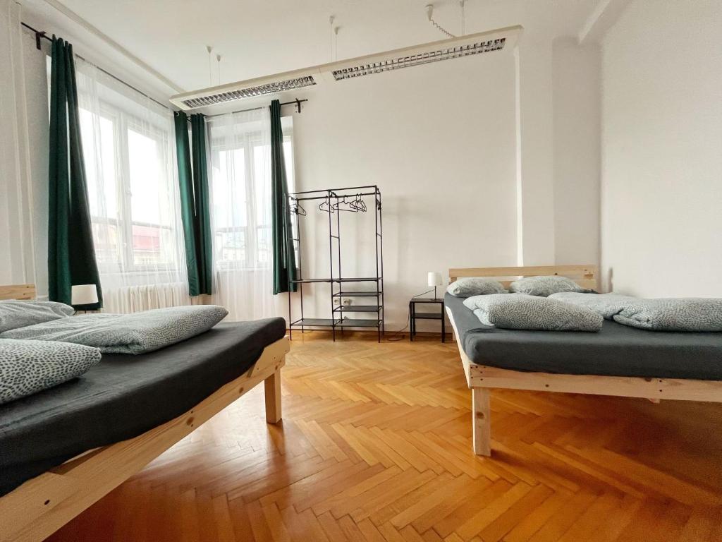 a room with two beds in it with green curtains at Nice View Rooms In Old Town in Kraków