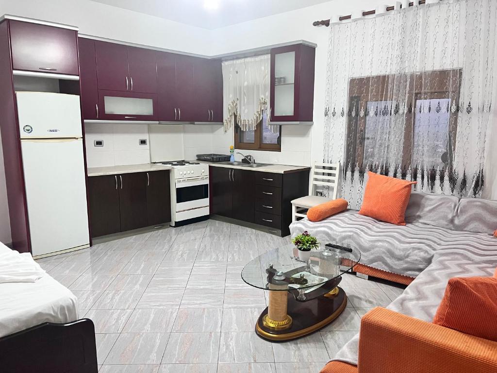 uma cozinha e sala de estar com um sofá e uma mesa em Kristina Apartament em Saranda