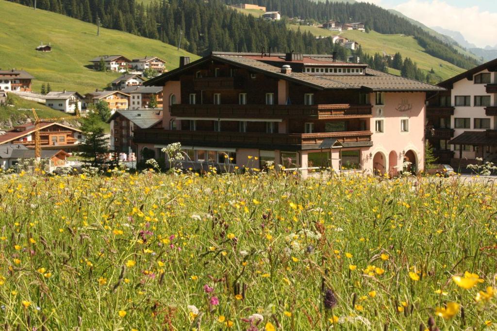 ein Blumenfeld vor einem Gebäude in der Unterkunft Hotel Garni Lärchenhof in Lech am Arlberg
