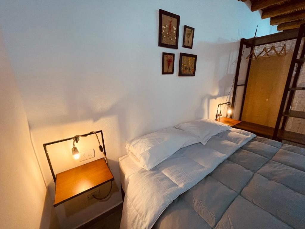 Un dormitorio con una cama grande y una mesa con una lámpara. en Monoambientes El viejo Olivo en Villa Unión