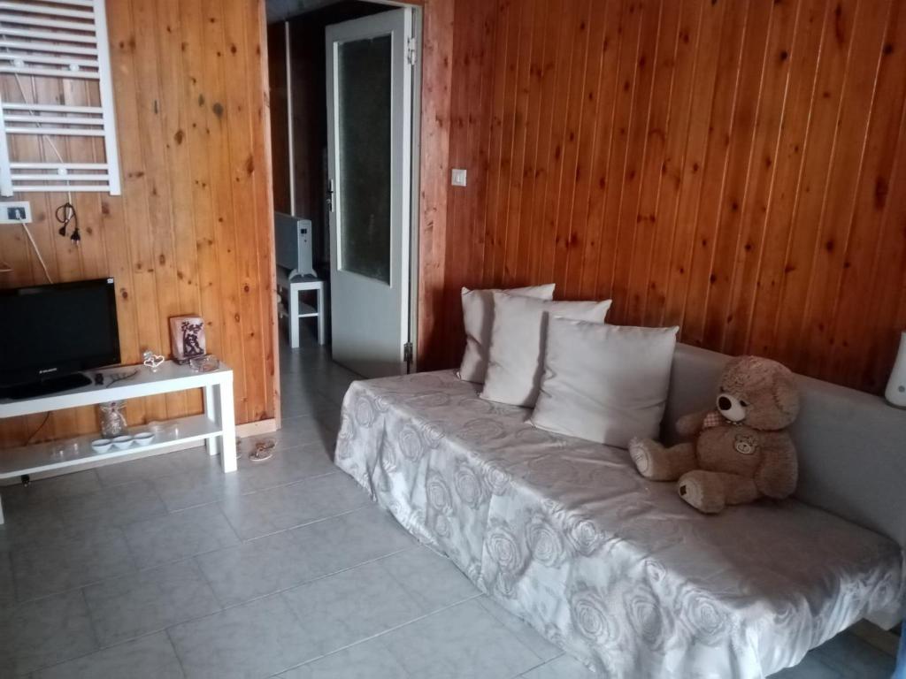 un osito de peluche sentado en una cama en una habitación en Palombeach en Ancona