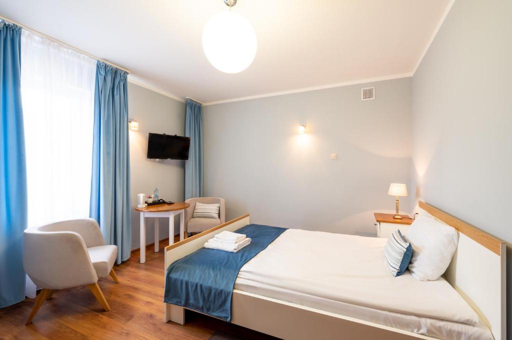 een hotelkamer met een bed en een stoel bij Hotel Rozmaryn i Lawenda in Minikowo