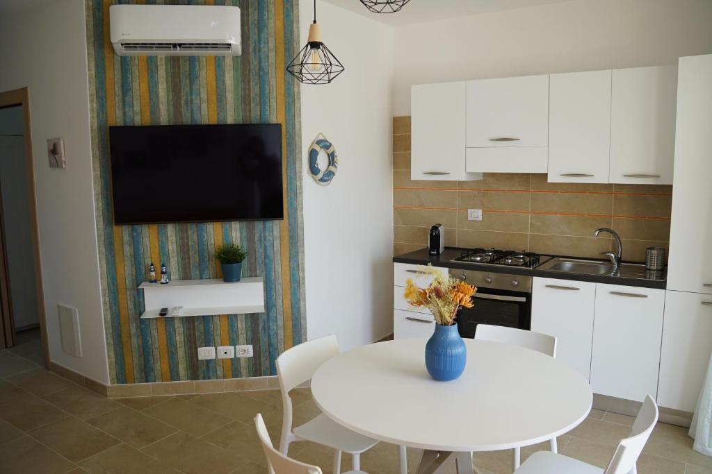 a kitchen with a white table with a vase of flowers at Rifugio di Mare - Appartamento Vasto Marina in Vasto