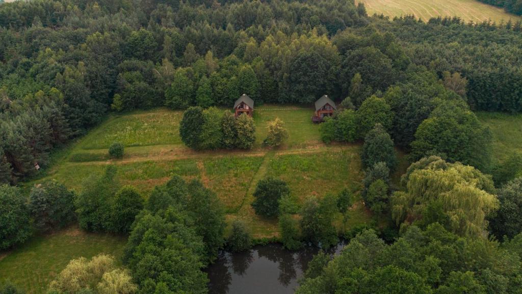 Na Pańskiej Górze في Brzozów: اطلالة جوية على منزل على تل بجوار بحيرة