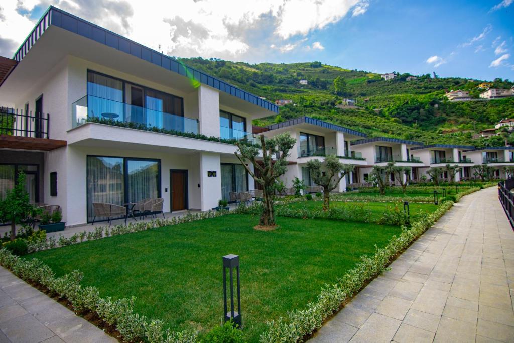 a row of houses with a green hill in the background at Hayal Vadisi Suite Hotel in Trabzon