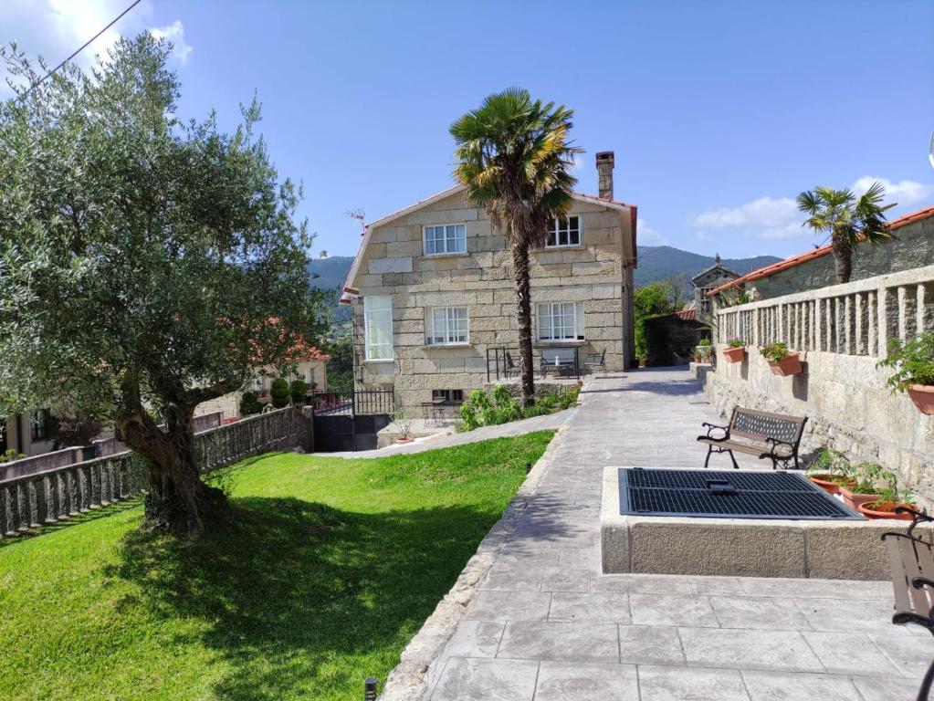 a garden with a bench and a house at A casa de Mateu in Pontevedra