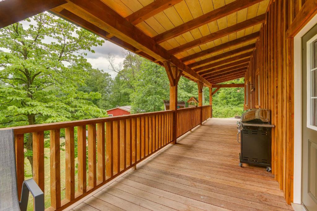 eine Veranda einer Holzhütte mit einem Herd darauf in der Unterkunft Cabin Rental Near Pennsylvania State Parks 