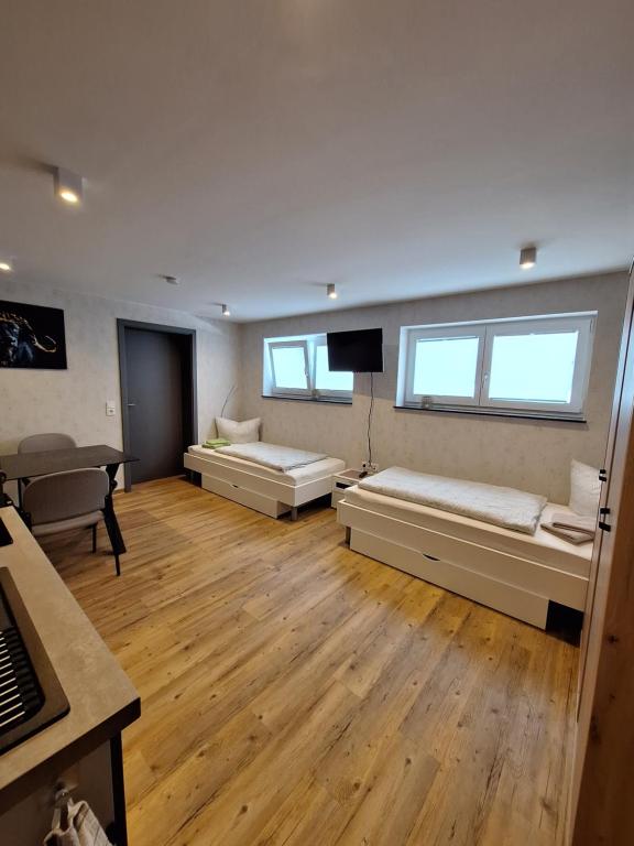 Großes Zimmer mit 2 Betten und einem TV. in der Unterkunft Pension Eichsfeld Zimmer 4 Standard in Breitenworbis