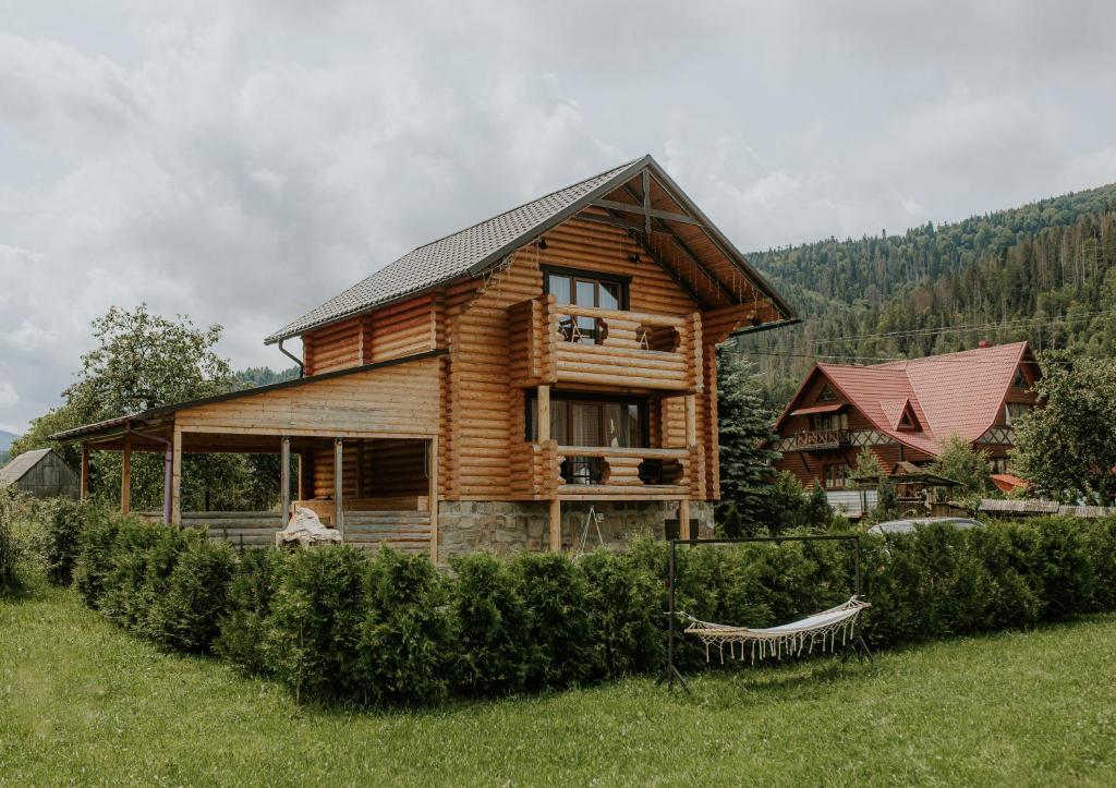 a log cabin in the middle of a field at Айворі Хаус in Mykulychyn