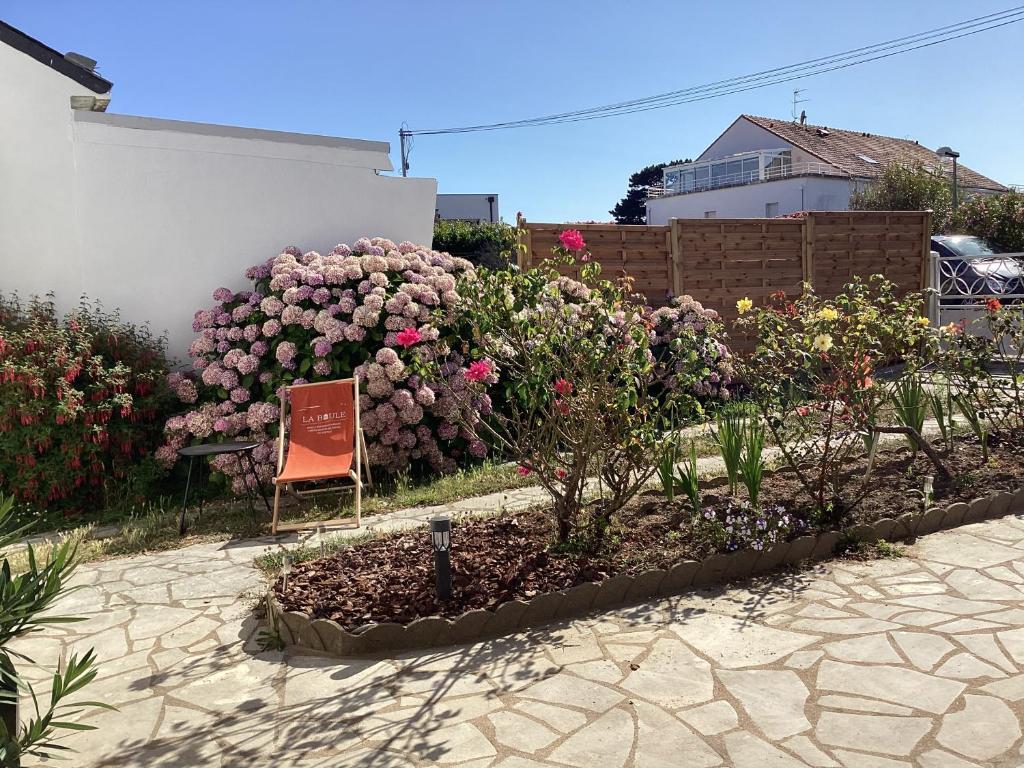 a garden with a bunch of flowers and a sign at Ker LN in Saint-Nazaire