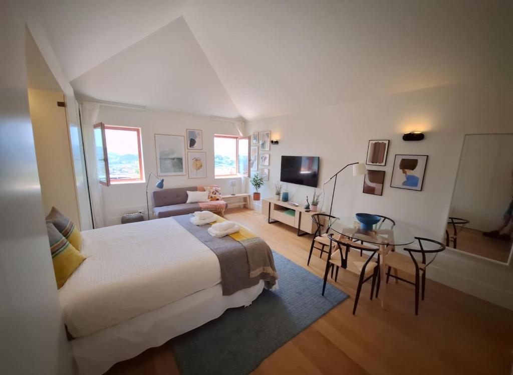 a bedroom with a large bed and a table at Fontainhas Hidden Gem in Porto