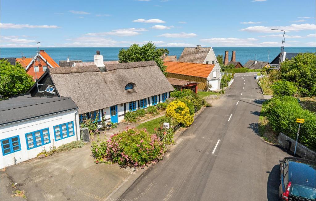 an empty street in a town with houses and the ocean at Amazing Home In Allinge With Wifi And 4 Bedrooms in Allinge