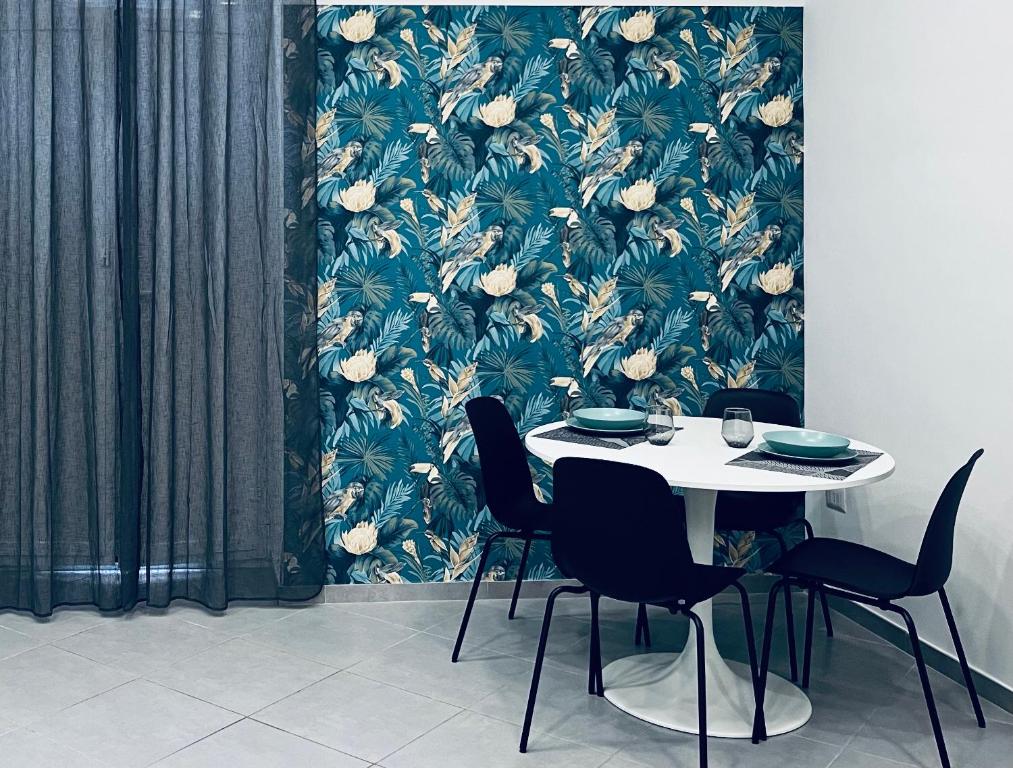 a table and chairs in a room with a floral wallpaper at La Casa di NAra in Naples