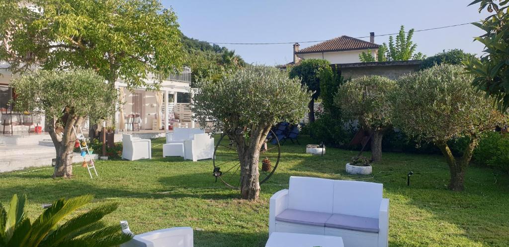un patio con muebles blancos, árboles y casas en CASE DI BACCO, en Agropoli
