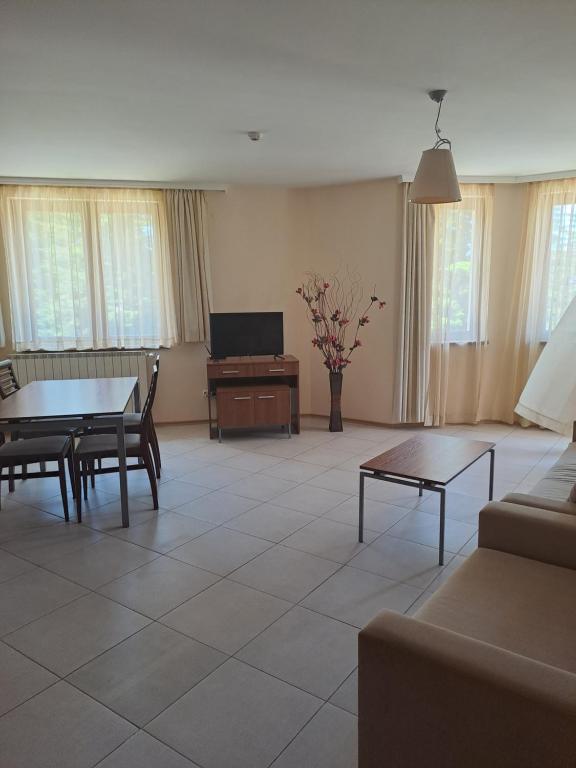 een woonkamer met een bank, een tafel en een televisie bij Rista apartment, Villa Park in Borovets