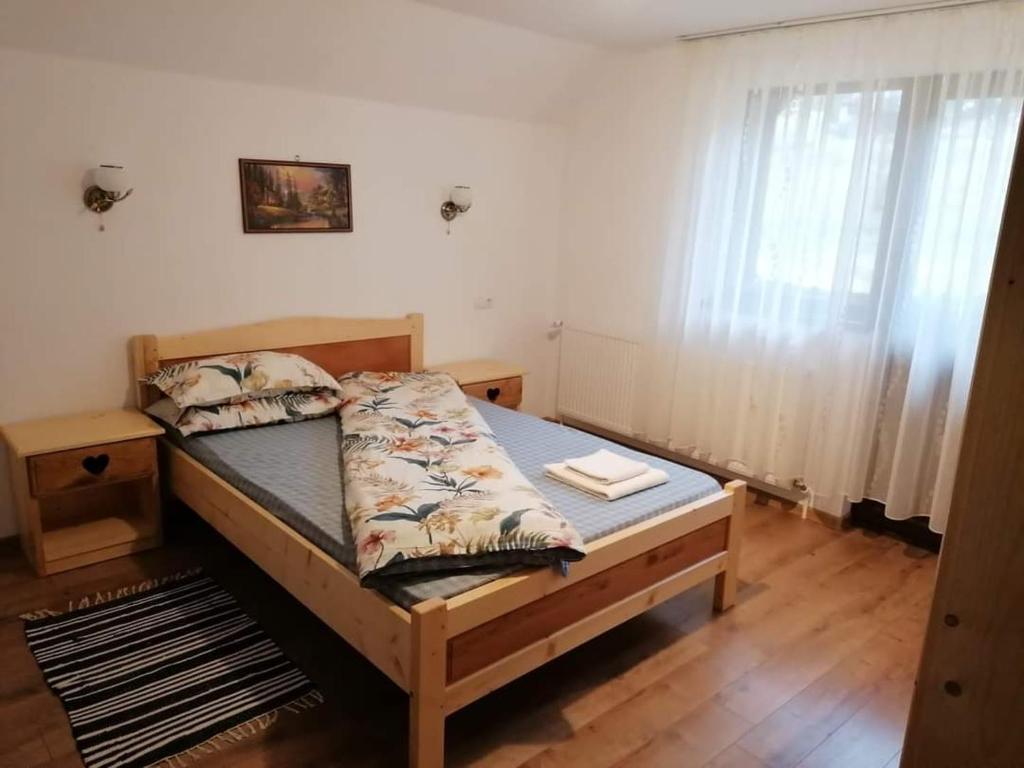 a bedroom with a bed with a wooden floor at Cabana Inima Munților in Gârda de Sus