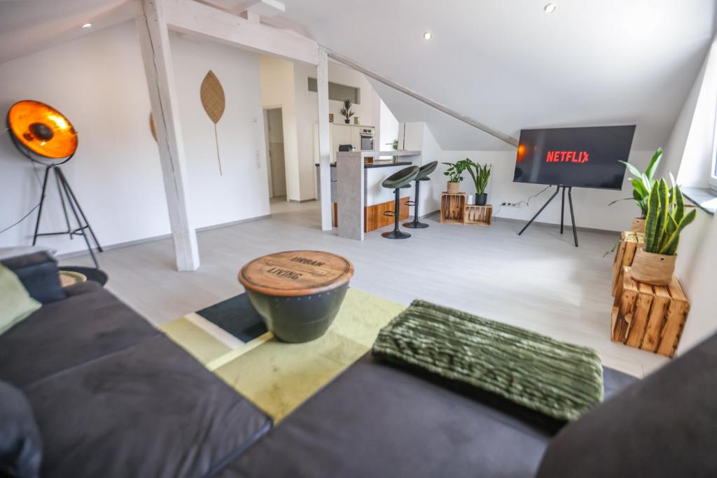 uma sala de estar com um sofá e uma mesa em Neu I Penthouse-Wohnung 100 qm I Blick auf die Weinreben I Nespresso em Auggen