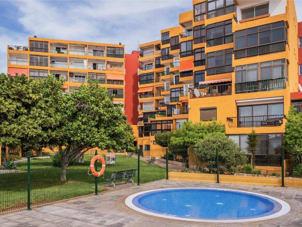 an apartment complex with a swimming pool in front of a building at Live el Poris chinchorro in Poris de Abona