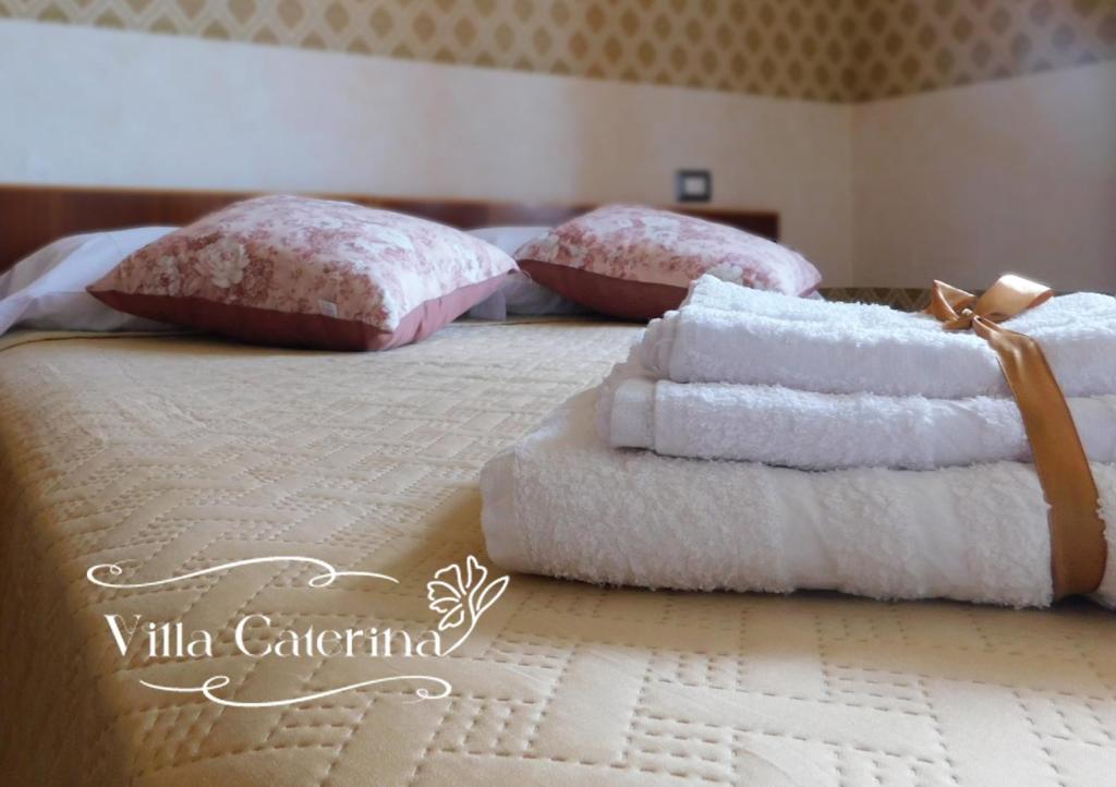 - une chambre avec 2 lits et des serviettes dans l'établissement Villa Caterina, à Fiuggi