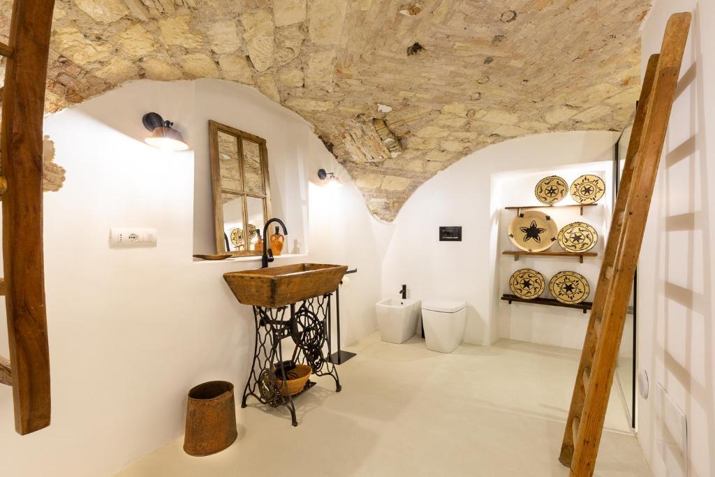 una stanza con lavandino e piatti appesi al muro di Crobi Museum and Suites a Cagliari