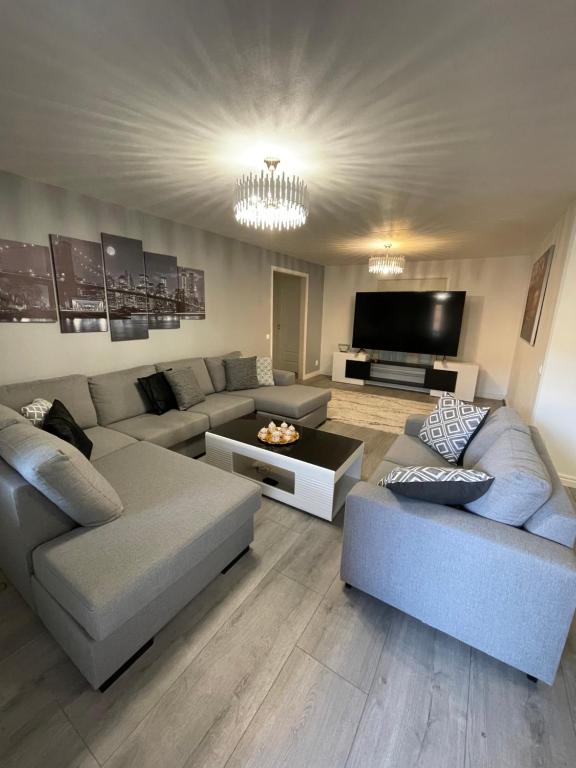 a living room with two couches and a flat screen tv at Central Apartment with 3 bedrooms in Norrköping