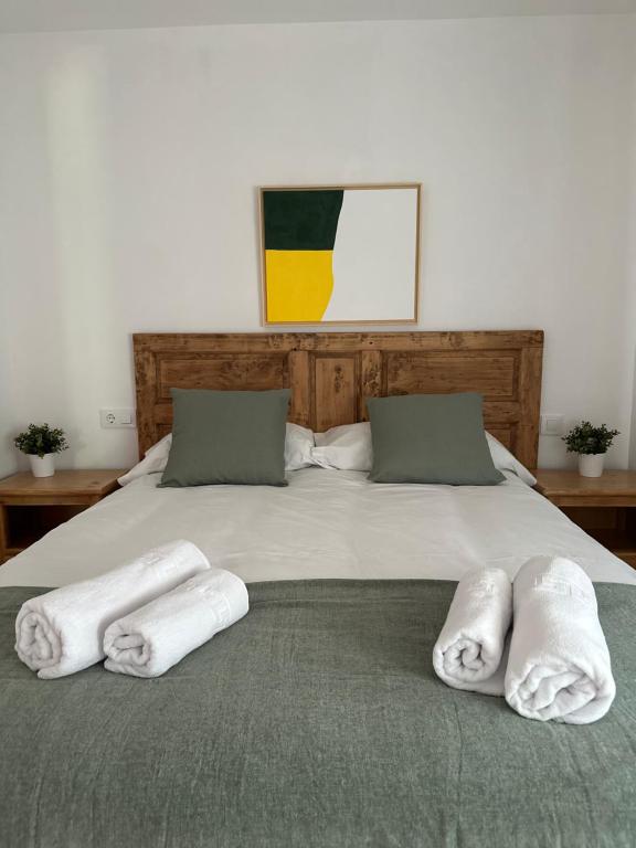 Una cama con tres toallas encima. en AIRE DE PICOS, en Brez