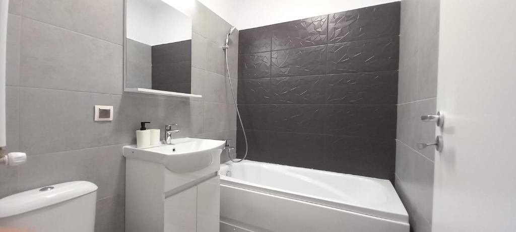 een badkamer met een wastafel, een toilet en een bad bij Modern 1BR apartment with wifi, parking and self check in in Boekarest