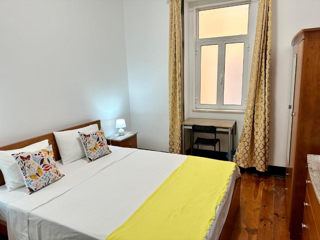 - une chambre avec un grand lit et une fenêtre dans l'établissement Sublime Yellow Bedroom, à Lisbonne
